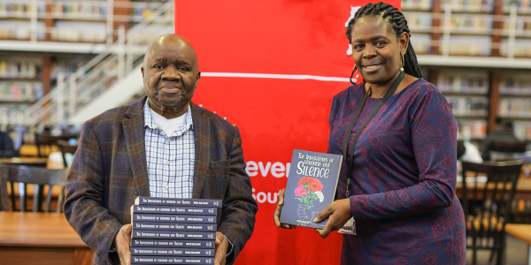 Hosia Malekane hands over 10 copies of his book to senior librarian Margaret Atsango at the William Cullen Library